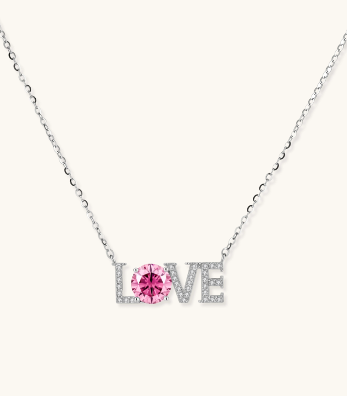 Sterling silver LOVE necklace with pink moissanite stone replacing the O, featuring crystal-set letters on delicate chain.