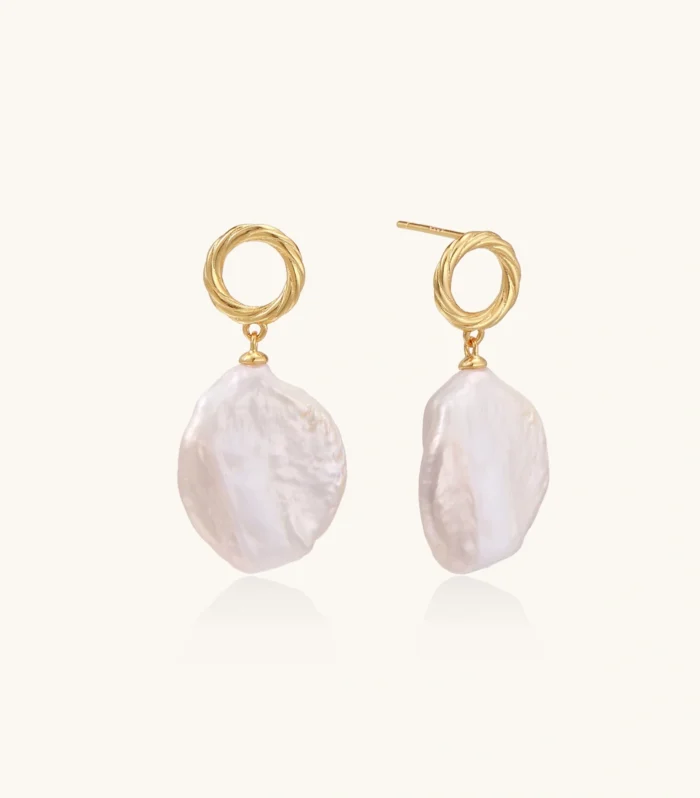 18K gold vermeil twisted circle studs with organic white baroque pearl drops on cream background
