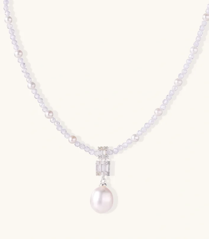 Dainty necklace with lavender crystal beads, freshwater pearls, geometric pendant, and large pearl drop on white background.