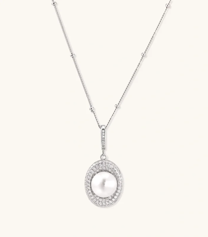 Oval sterling silver pendant with crystal halo surrounding a white freshwater pearl on delicate chain