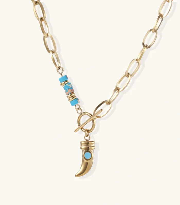Gold chunky chain necklace with turquoise beaded accent and horn pendant on white background