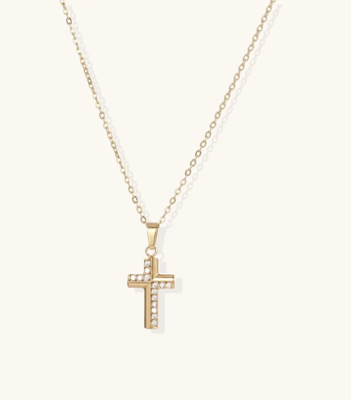 Gold-plated stainless steel cross necklace with crystal embellishments on adjustable chain against light background.