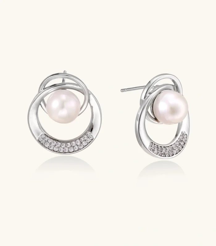 White gold-plated brass earrings with circular design, freshwater pearl center, and diamond accents