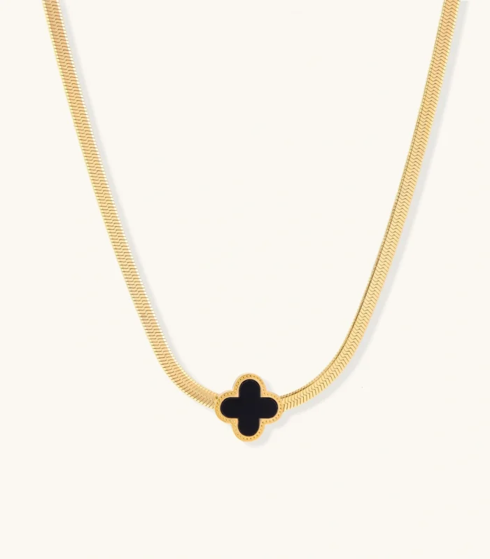 Dainty 18K gold-plated herringbone chain necklace with black enamel quatrefoil clover pendant on white background
