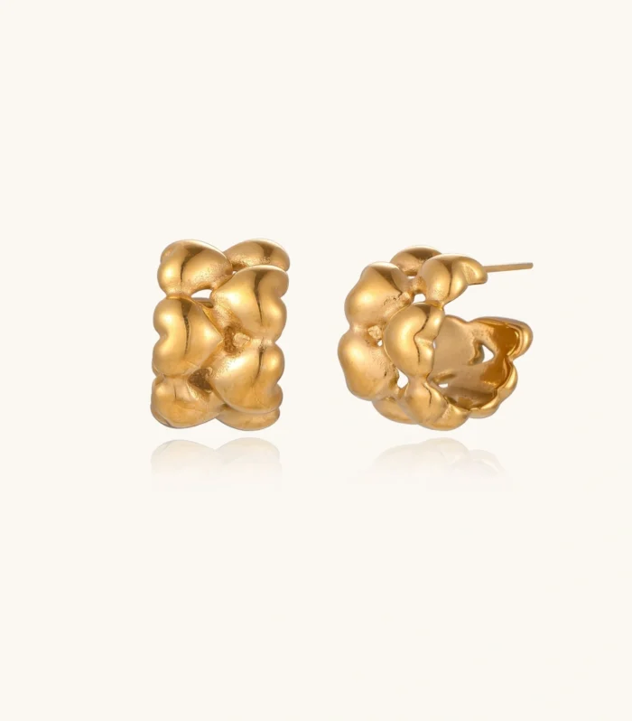 Close-up of gold-plated twisted rope huggie hoop earrings with brushed finish on white background.