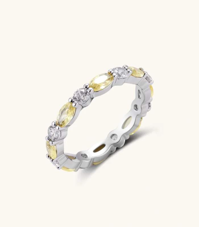 Platinum-plated copper ring with alternating clear and pale yellow oval stones in an eternity band design on white background.